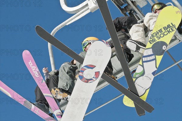 Snowboarders and skiers on a ski lift