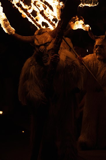 Klausen mask with burning horns and trident in the dark