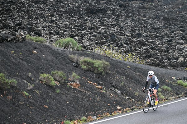 Road cyclist on the road through Timanfaya National Park