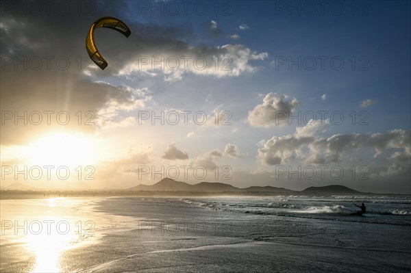 Kitesurfers at sunset on the beach of Caleta de Famara