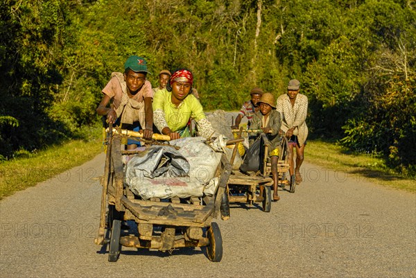 Young boys pushing self made carts up the hill