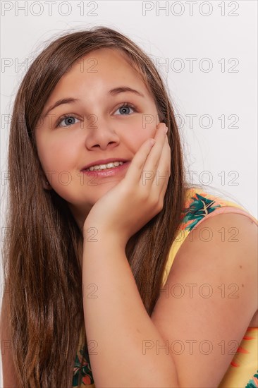 Portrait of a girl with long hair supporting her chin with her hand