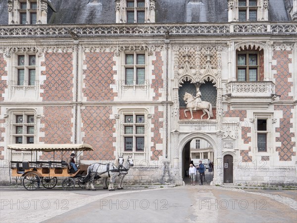 Equestrian statue of Louis XII above the entrance to the Chateau Royal de Blois and a carriage with two white horses