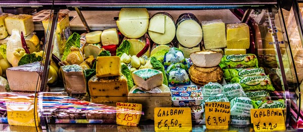 Ham and cheese stall at the historic fish market La pescheria with an abundance of colourful seafood