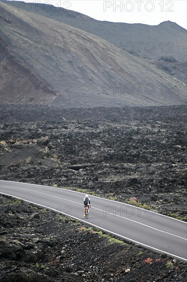 Road cyclist on the road through Timanfaya National Park