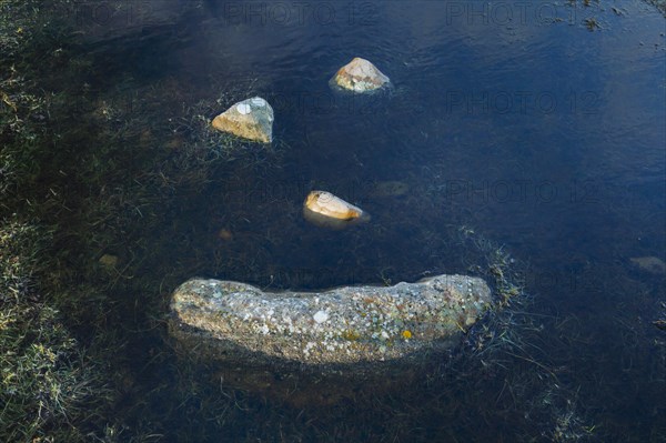 A natural smiley made of stones in the middle of a puddle of water in the Highlands of Scotland