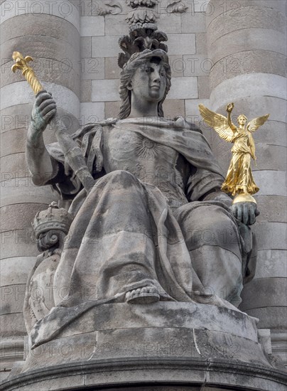 A sculpture of a woman with another small golden sculpture in her hand at the beginning of a column on the Pont Alexandre III