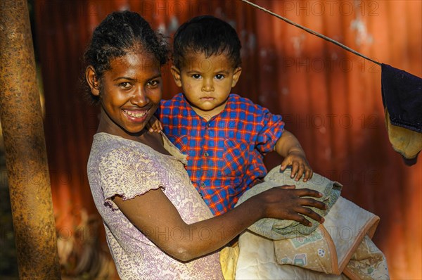 Friendly girl holding a child in her arms