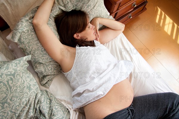 Pregnant woman resting on her bed