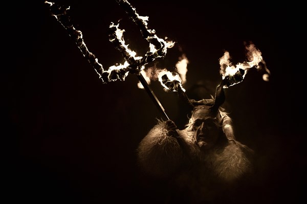 Klausen mask with burning horns and trident in the dark