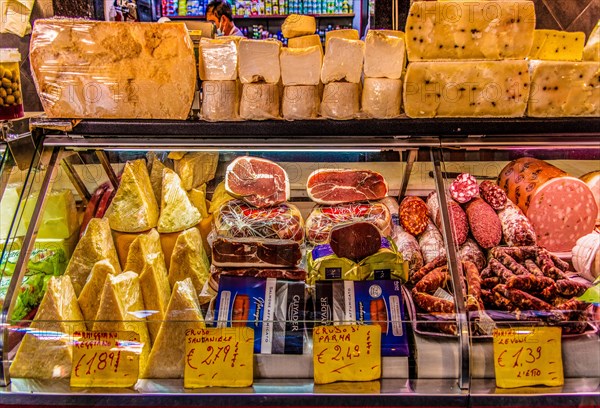 Ham and cheese stall at the historic fish market La pescheria with an abundance of colourful seafood