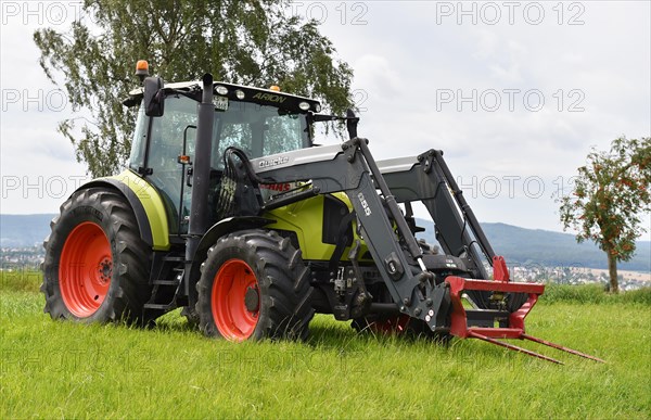 Tractor with bale fork for stacking round bales