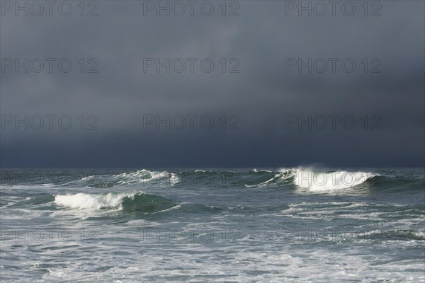 Big waves crashing in the open sea and dramatic light off the north coast of Ireland