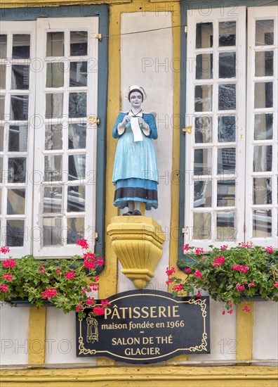 Detail of the half-timbered house with statue of a woman in historical traditional costume in the Rue Kereon