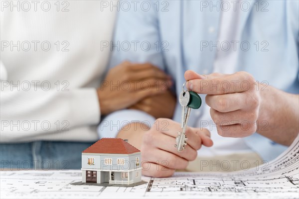 Embraced defocused couple holding keys their new house