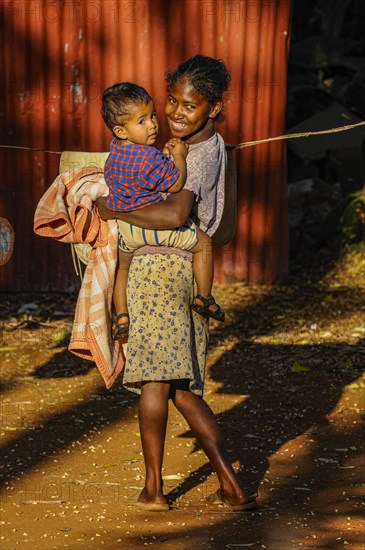 Friendly girl holding a child in her arms