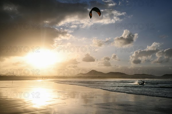 Kitesurfers at sunset on the beach of Caleta de Famara