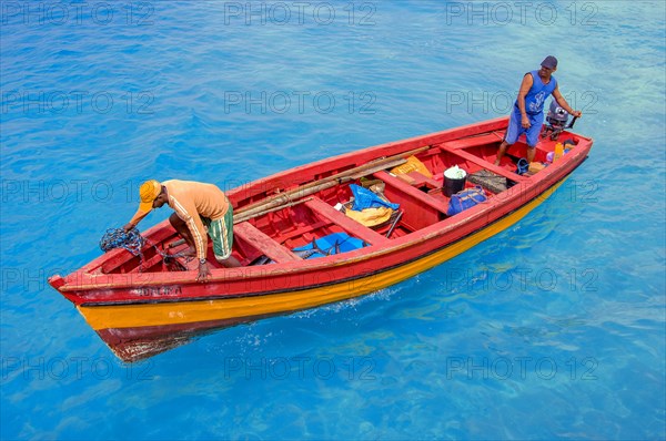Coloured fishing boat enters harbour lagoon