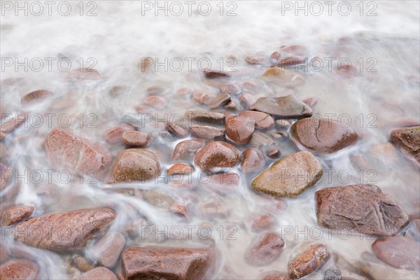 Detail of the swell on a red stone beach on the north-west coast of Scotland