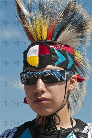 Young Blackfoot boy in traditional regalia and sunglasses