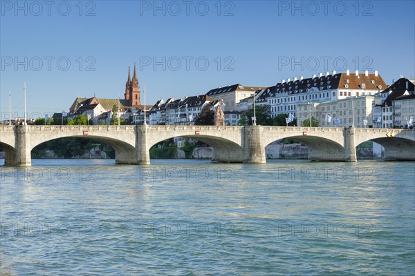 View from the banks of the Rhine along the river promenade to the old town of Basel with the Basel Cathedral