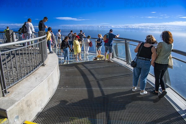 Tourists look at the view from the glass-bottom skywalk