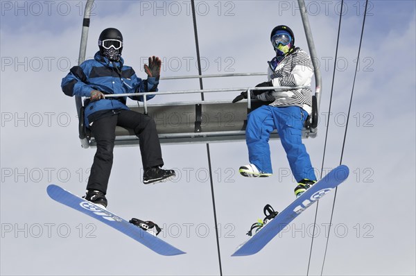 Snowboarders on a ski lift