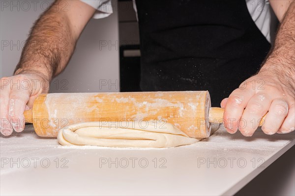 Confectioner man baking homemade croissant