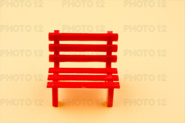 Little red miniature bench made of plastic