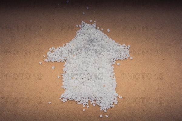 Arrow formed by some white sand on brown paper