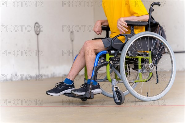 Detail of a disabled person in a wheelchair at a Basque pelota game fronton