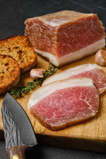 Closeup view of salted pork belly joint meat with lard on wooden cutting board