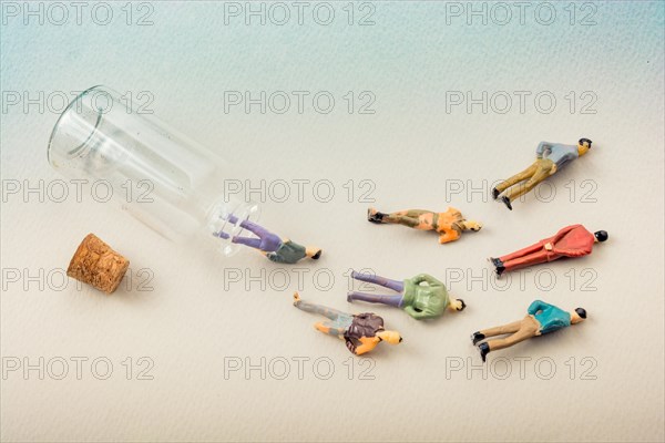 Tiny figurine of men miniature model coming out of bottle