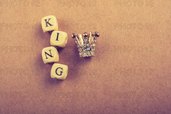Tiny model crown beside the king wording on brown