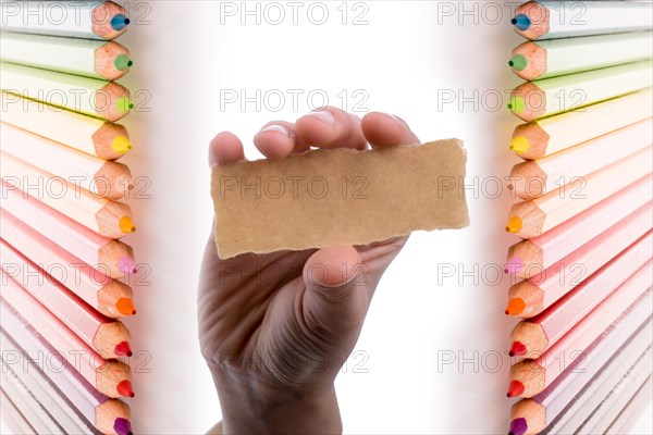 Hand holding a piece of blank torn notepaper