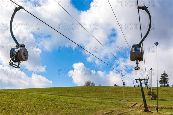 Ski lift at standstill due to lack of snow caused by climate change at the end of winter on a hill in Muensingen