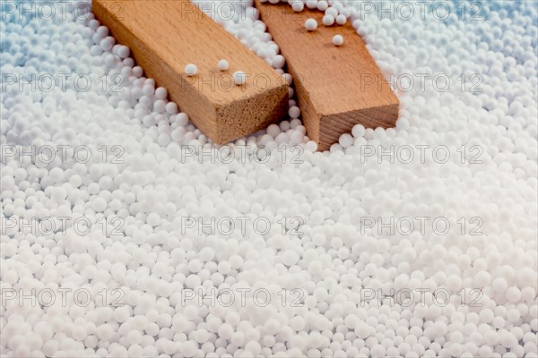 Wooden blocks in White polystyrene foam balls as background