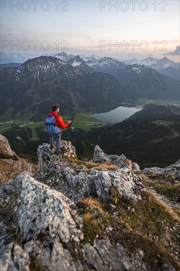 Hiker at the summit of Schartschrofen at sunset