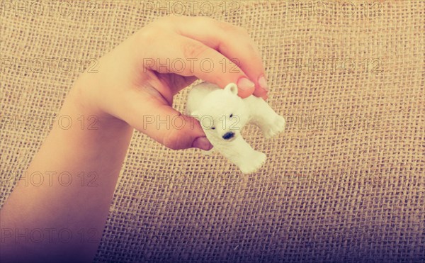 Hand holding a Polar bear model in hand on canvas