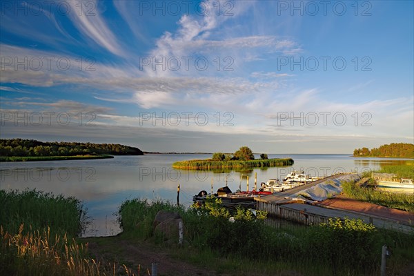 Small harbour with boats and quiet bay of the Baltic Sea in the evening light