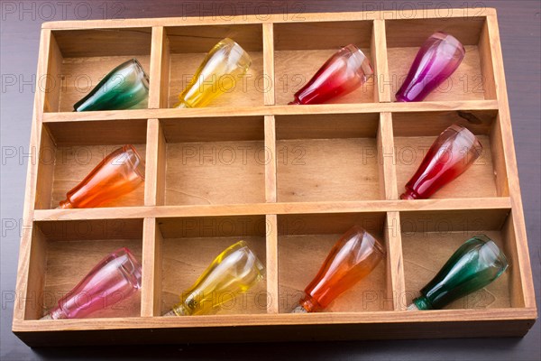Colorful small bottles in a wooden box in the view