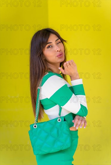 Portrait of a Caucasian girl in a white striped sweater on a green background