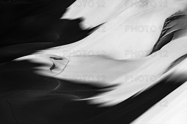 Ski touring trail in deep snowy mountain landscape with light and shadow