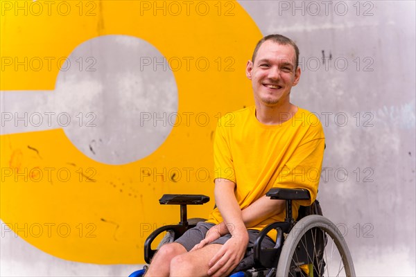 A disabled person in a wheelchair with a cement wall