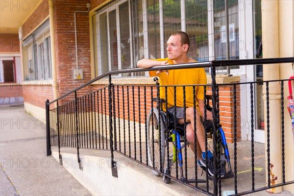 Portrait of serious disabled person in yellow dress in wheelchair at school