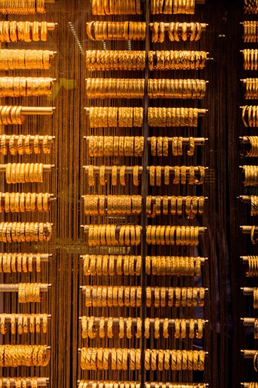 Shop display of dozens of golden bracelets and bangles