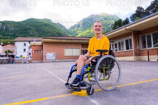 Portrait of a disabled person dressed in yellow in a wheelchair in the schoolyard