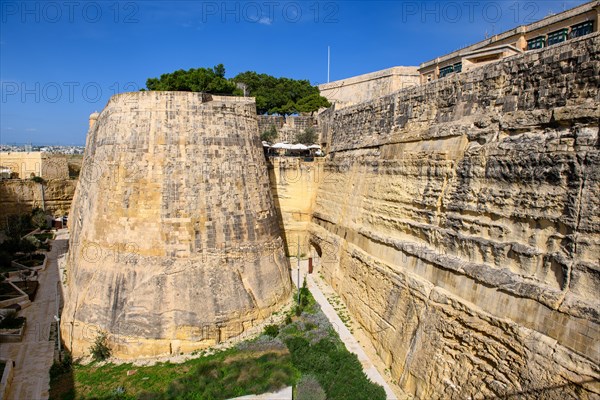 Historic city wall with remains of round watchtower of capital of Malta La Valletta to the land side