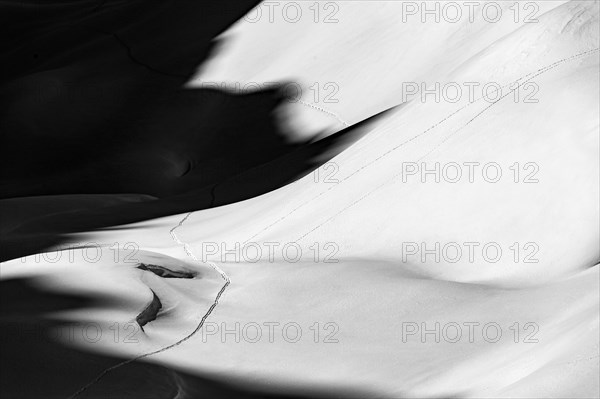 Ski touring trail in deep snowy mountain landscape with light and shadow