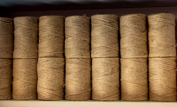 Plenty of spools or rolls of brown color linen string